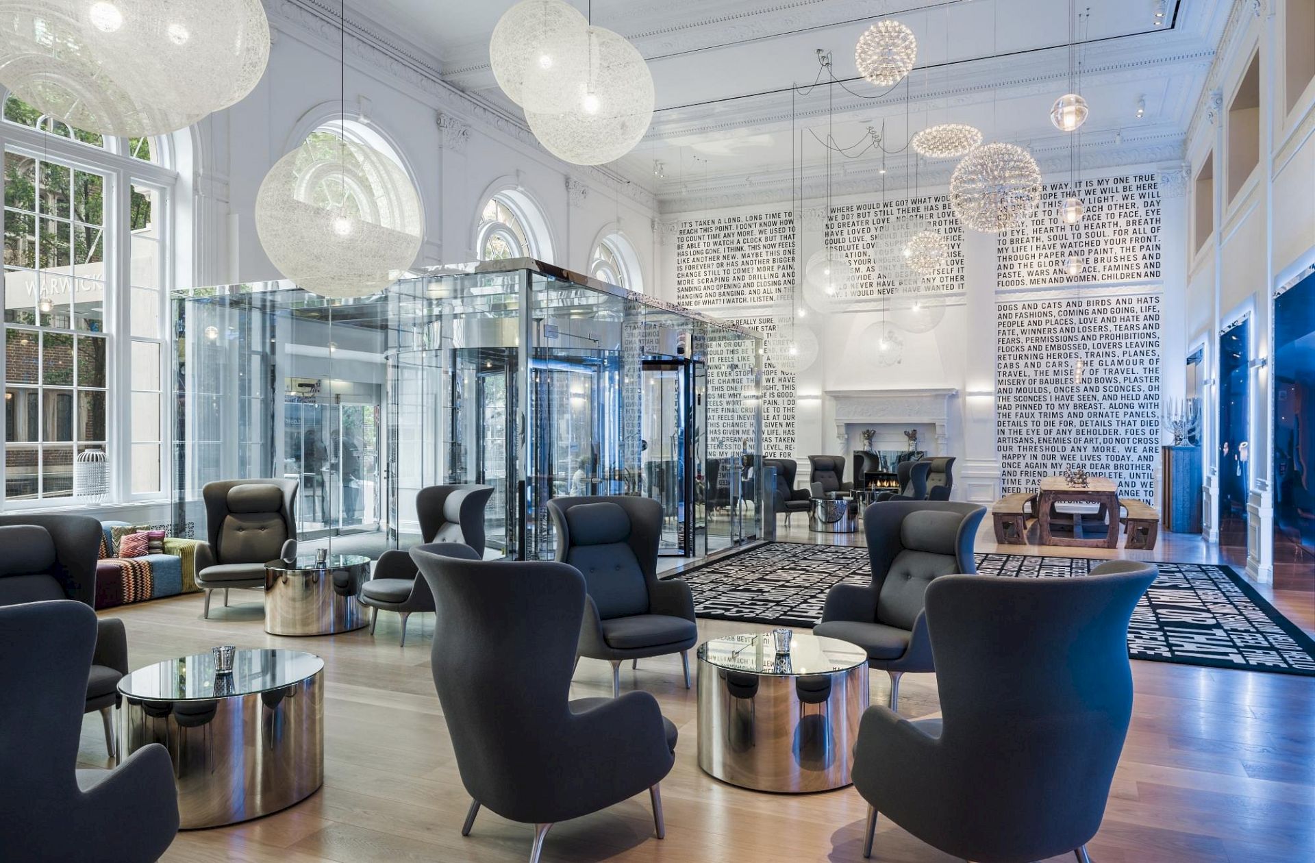 The image shows a modern, spacious lounge area with high ceilings, large windows, contemporary furniture, and stylish lighting fixtures, ending the sentence.
