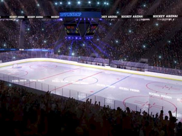 The image depicts a brightly lit hockey arena filled with spectators. The ice rink is central, and a scoreboard hangs above the rink.